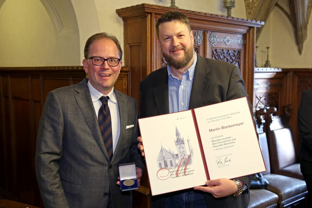 Bürgermeister Manuel Pretzl überreicht Filmwerkstatt-Vorstand Martin Blankemeyer die Medaille "München leuchtet"